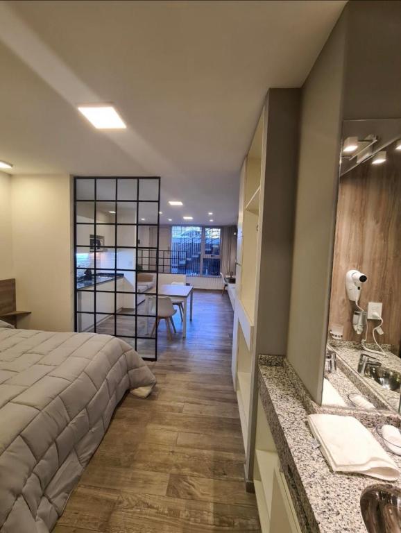 a bedroom with a bed and a bathroom with a sink at Espacios Plaza VM in Villa María