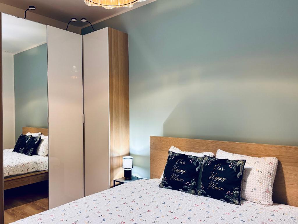 a bedroom with a bed and a mirror at Gold Key komfortowy apartament z balkonem, klimatyzacja i parkingiem in Pruszków