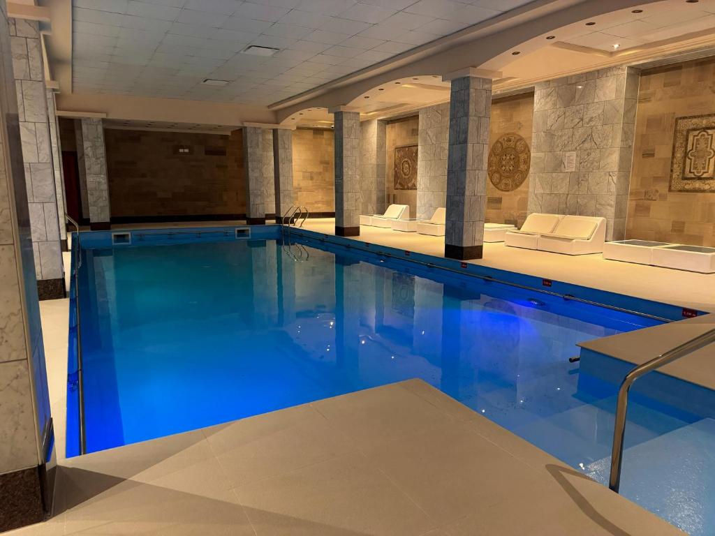 a swimming pool with blue water in a building at Status Hotel in Río Grande