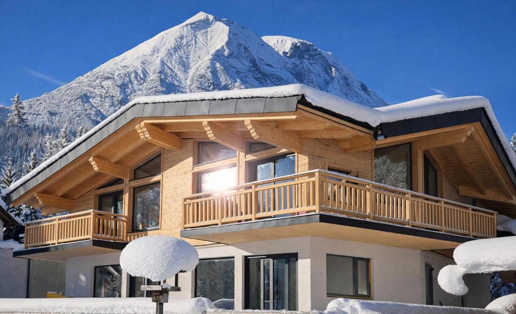 a house in front of a snow covered mountain at NEUBAU Alpinstar Chalet - Luxus, Bergblick, Loipe, Sauna in Leutasch