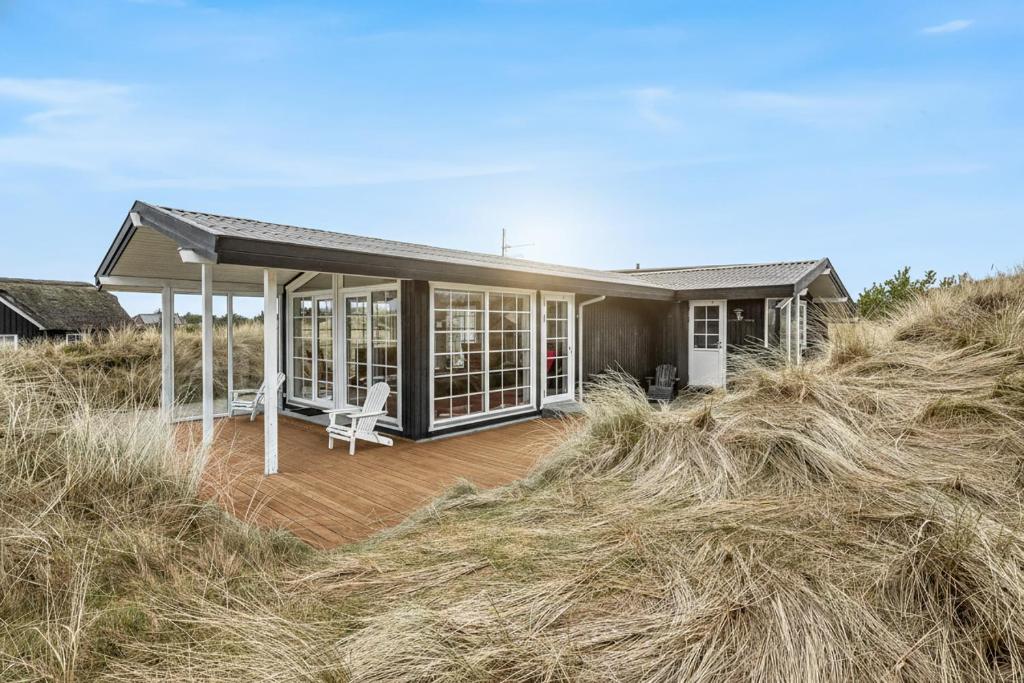 a house sitting on top of a field of hay at Feriehus 1103 in Ringkøbing