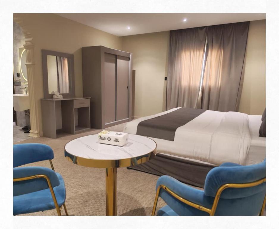 ein Hotelzimmer mit Bett, Tisch und Stühlen in der Unterkunft فخامة العزيزية in Al-'Ula