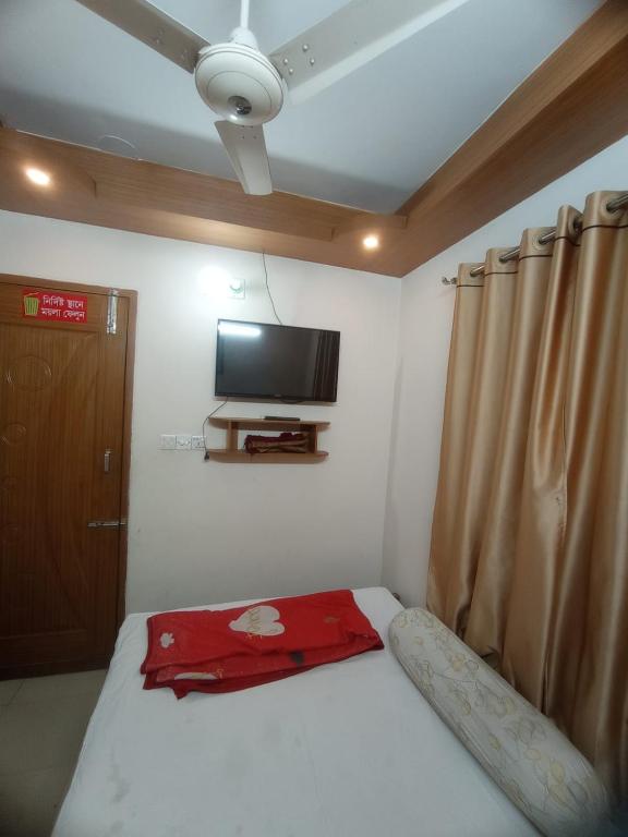 a bedroom with a bed with a tv on the wall at Hotel Sikder-02 Residential in Dhaka