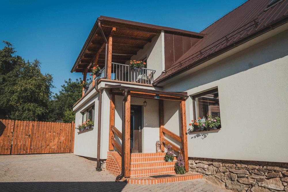 a house with a staircase and a balcony with flowers at Ubytování Třemešek in Šumperk