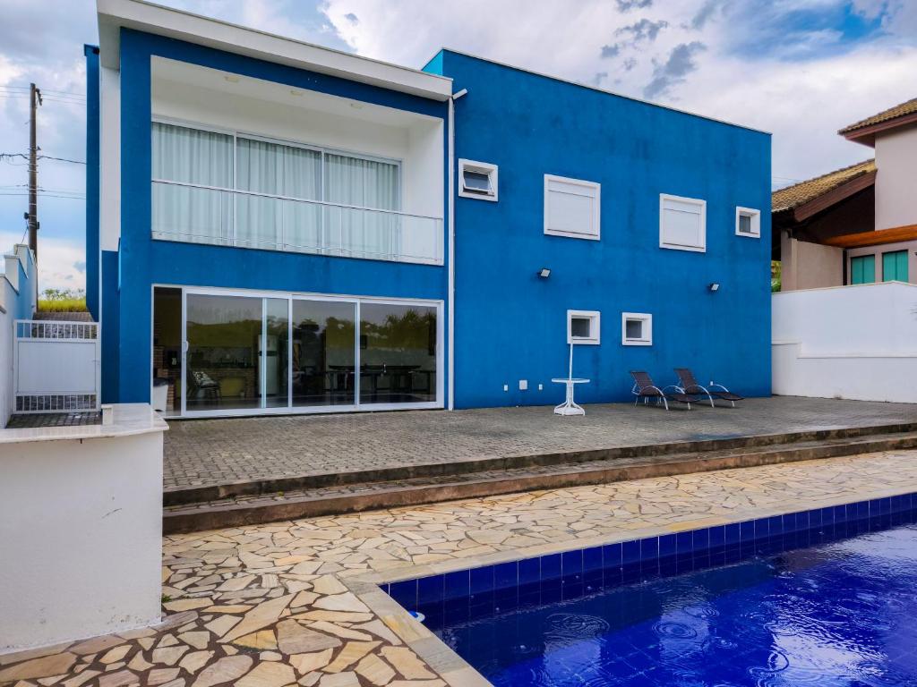 a blue building with a pool in front of it at Casaazulvaleparaiba in Jacareí