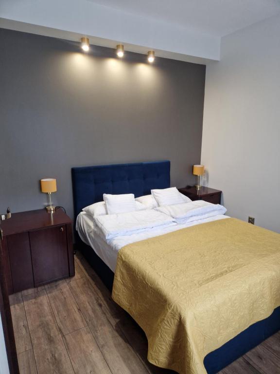 a bedroom with a large bed and two night stands at Granatowy odpoczynek - wieś Pogórze dla zmotoryzowanych in Pogórze