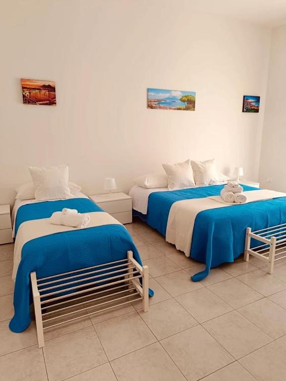 two beds with blue and white sheets in a room at B&B Torrebianca in Aversa