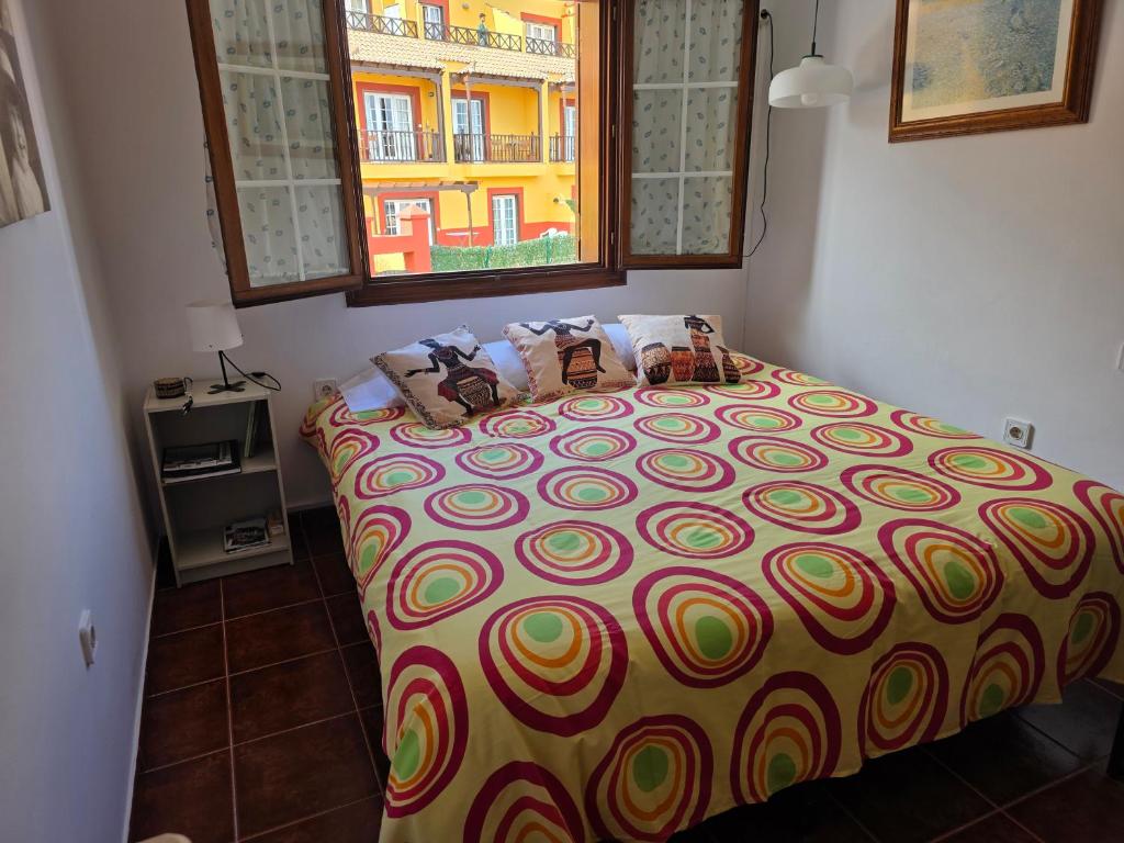 a bedroom with a bed with a colorful bedspread at Lourdes 1 casa compartida solo con la anfitriona in Breña Baja