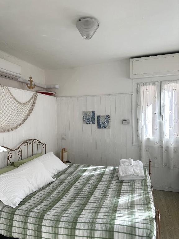 a bedroom with a large bed with a green and white blanket at Villa Bruna B&B in Sanremo