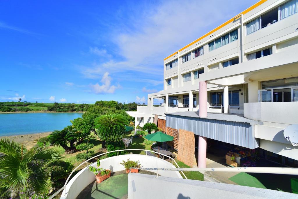an apartment building with a view of a body of water at Hotel South Island in Miyako Island