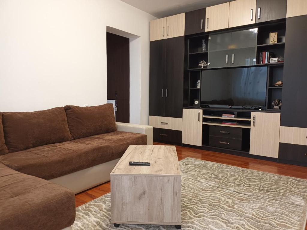 a living room with a couch and a tv at Apartament Magic Petroșani in Petroşani