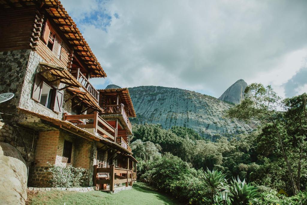 a building with a mountain in the background at Pousada Peterle in Domingos Martins