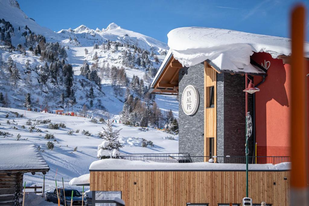 a building with a clock on it in the snow at Smarthotel inAlpe in Obertauern