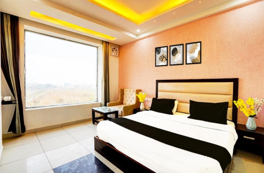 a bedroom with a large bed and a large window at Hotel Aroma Regency in Meerut
