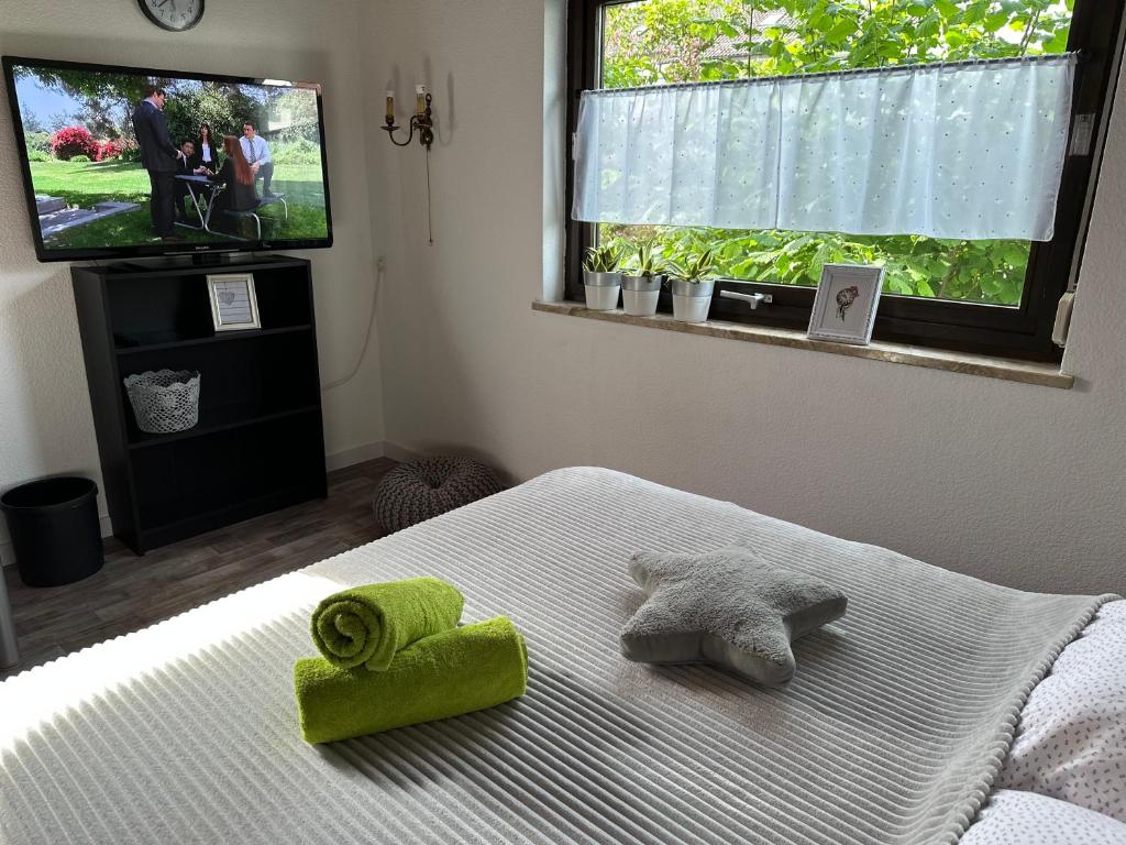 a bedroom with a bed with green towels on it at Zimmer, Apartment A3 in Offenberg