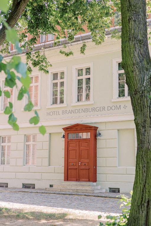 a building with a red door in front of it at Hotel Brandenburger Dom in Brandenburg an der Havel