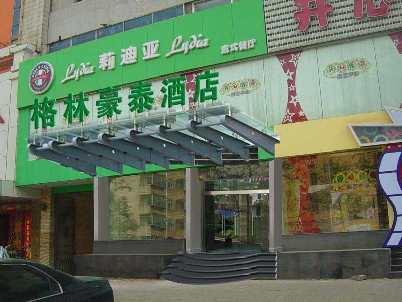 a building with a green sign on the side of it at GreenTree Inn Ji‘nan Shanda Road Business Hotel in Jinan