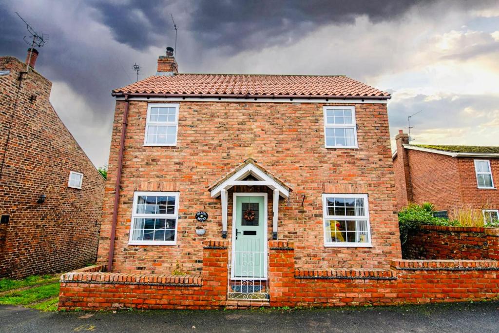 a red brick house with a white door at Chapel Bricks in Withernwick
