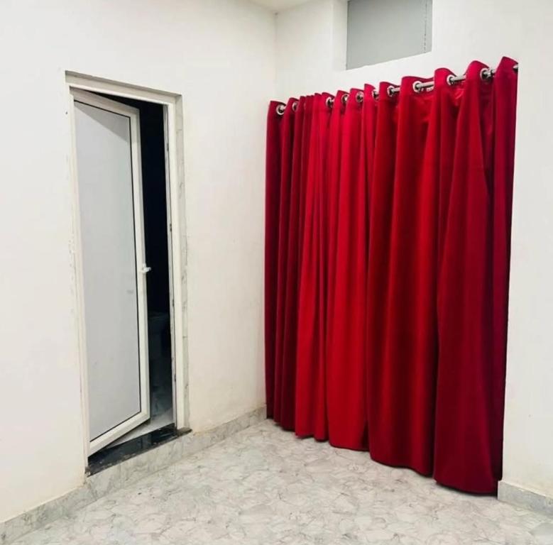 a pair of red curtains in a room with a door at Lallan Top Hotel in Unnāo