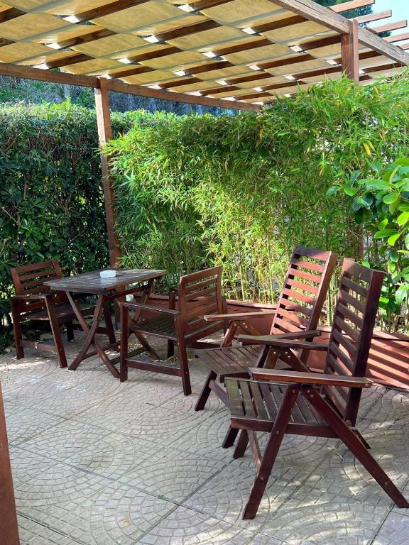 a picnic table and chairs under a wooden pergola at Da Elio Case Vacanza e Stanze in San Domino