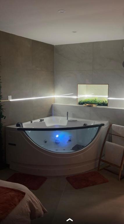 a large bath tub with a blue light in a room at esperanza in Vizille