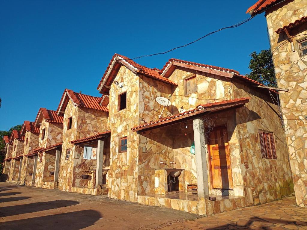 a row of stone buildings on a street at Chalé Nascer do Sol in São Thomé das Letras