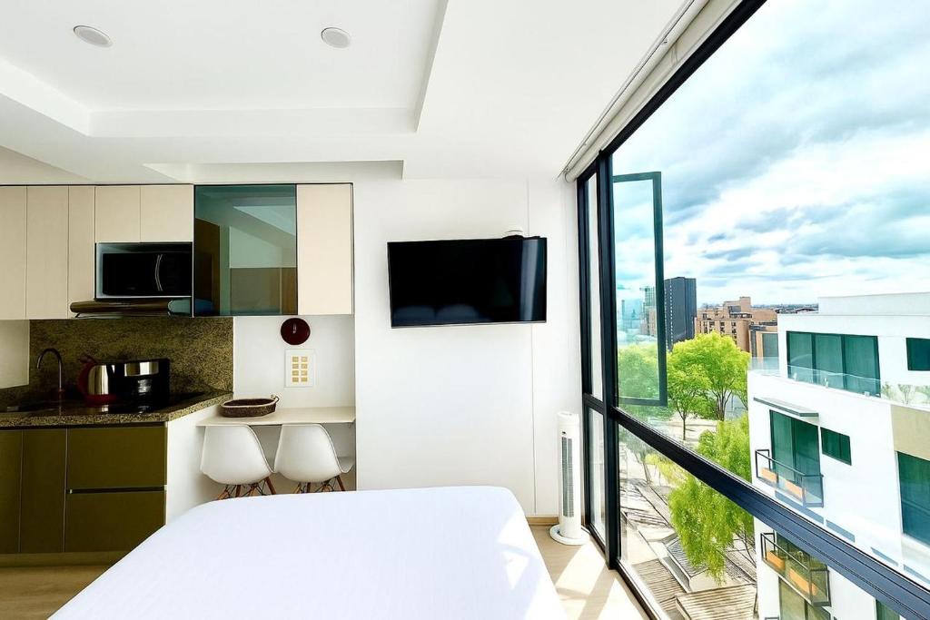 a bedroom with a bed and a large window at Exclusive Tiny Loft in Usaquén in Bogotá