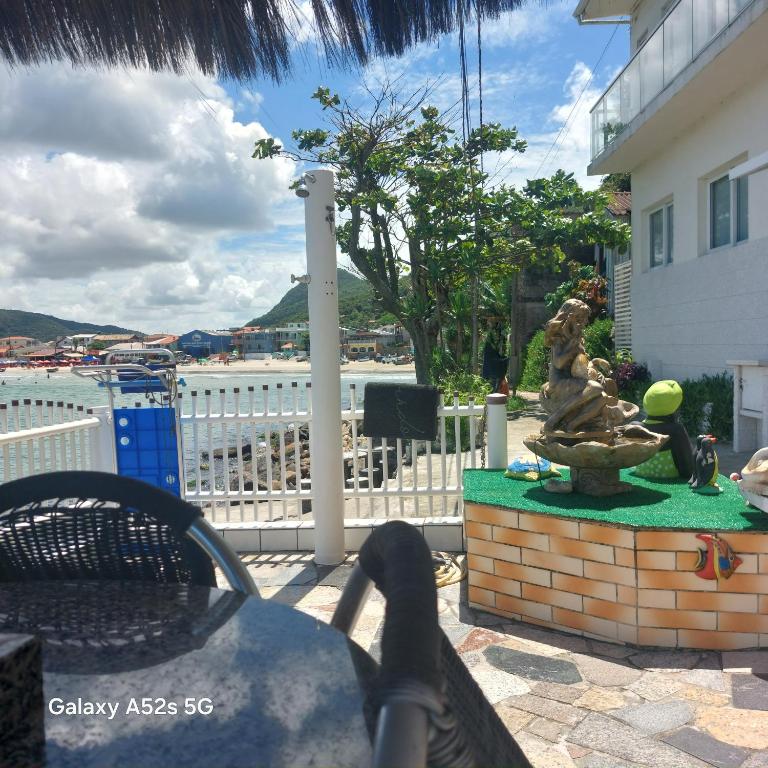 a person sitting at a table with their feet on a patio at Apartamento no Costão do Pântano do Sul in Florianópolis