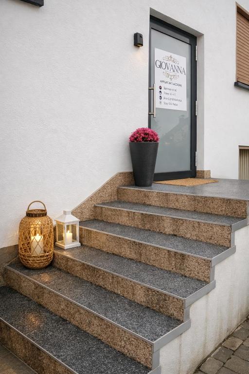 a lantern sitting on the stairs in front of a door at Giovanna Ferienwohnung in Müllenbach