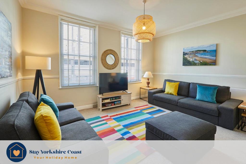 a living room with a couch and a tv at Painters Modern Apartment Central Location in Scarborough
