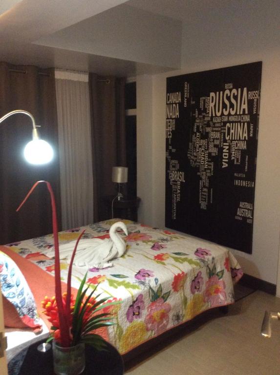 a bedroom with a bed with a white bird on it at Condo at Parkside Villas across the airport in Manila