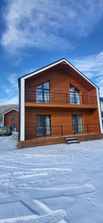 a large wooden building with snow in front of it at Barnhous in Mykulychyn