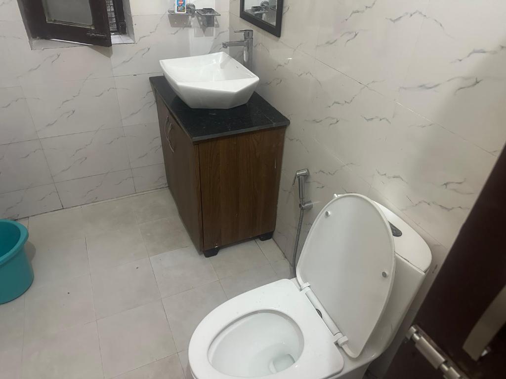 a bathroom with a toilet and a sink at Peaceful Pines Cottage in Bhowāli