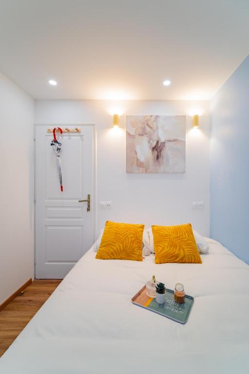 a bedroom with a white bed with orange pillows at Paris - Blue Sky Homestay in Le Kremlin-Bicêtre