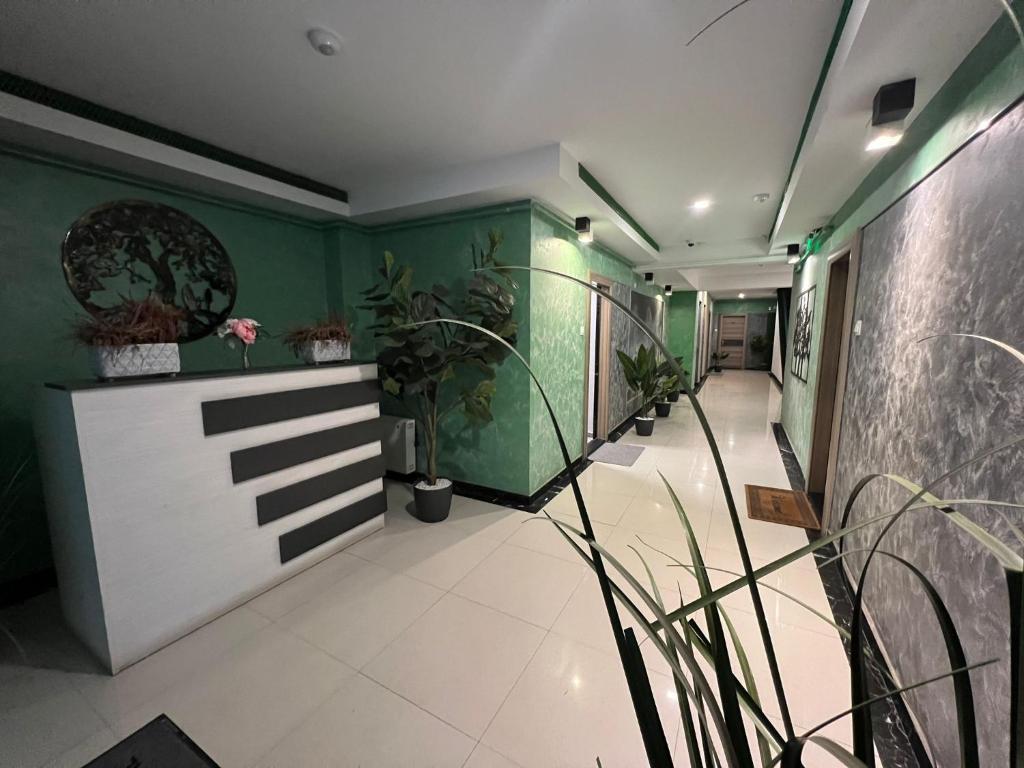a hallway with green walls and white floors and plants at marius in Chiajna