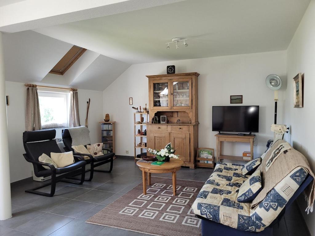 ein Wohnzimmer mit Sofa und Fernseher in der Unterkunft Apartment Libramont in Libramont