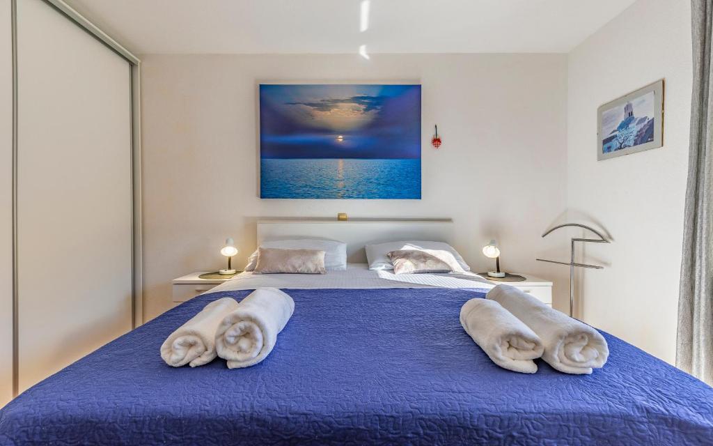 a bedroom with two towels on a blue bed at Good choice in Valbandon