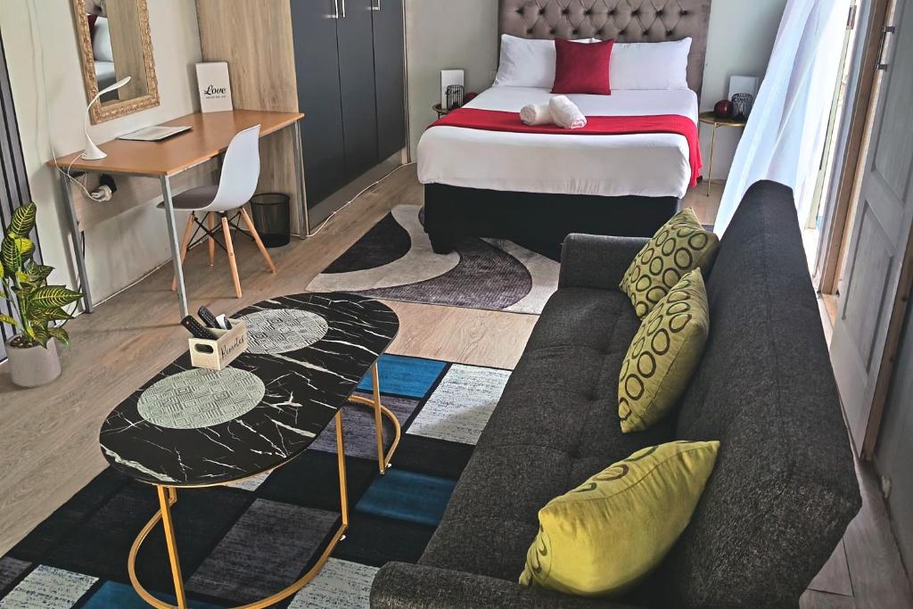 a living room with a couch and a bed at The Converted Space in Welkom