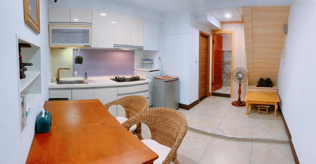 a kitchen with a wooden table and chairs at Chongguang Hotel in Tainan