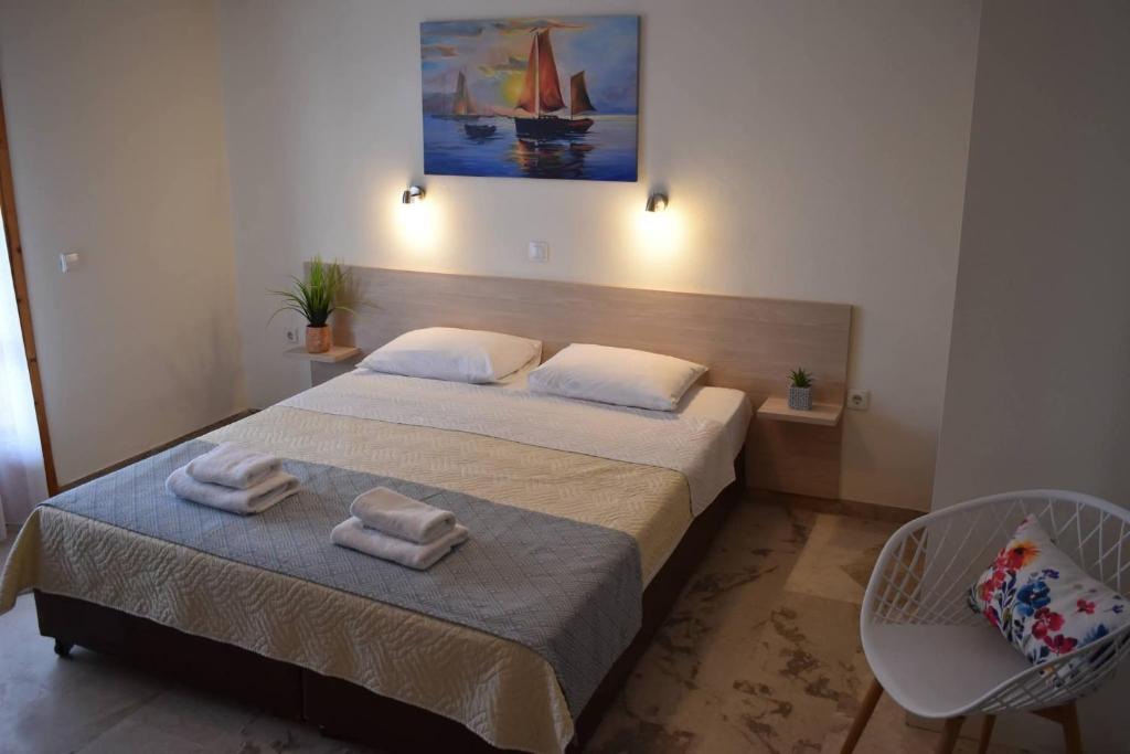 a bedroom with a bed with towels on it at Tolo Blue Bay in Tolo