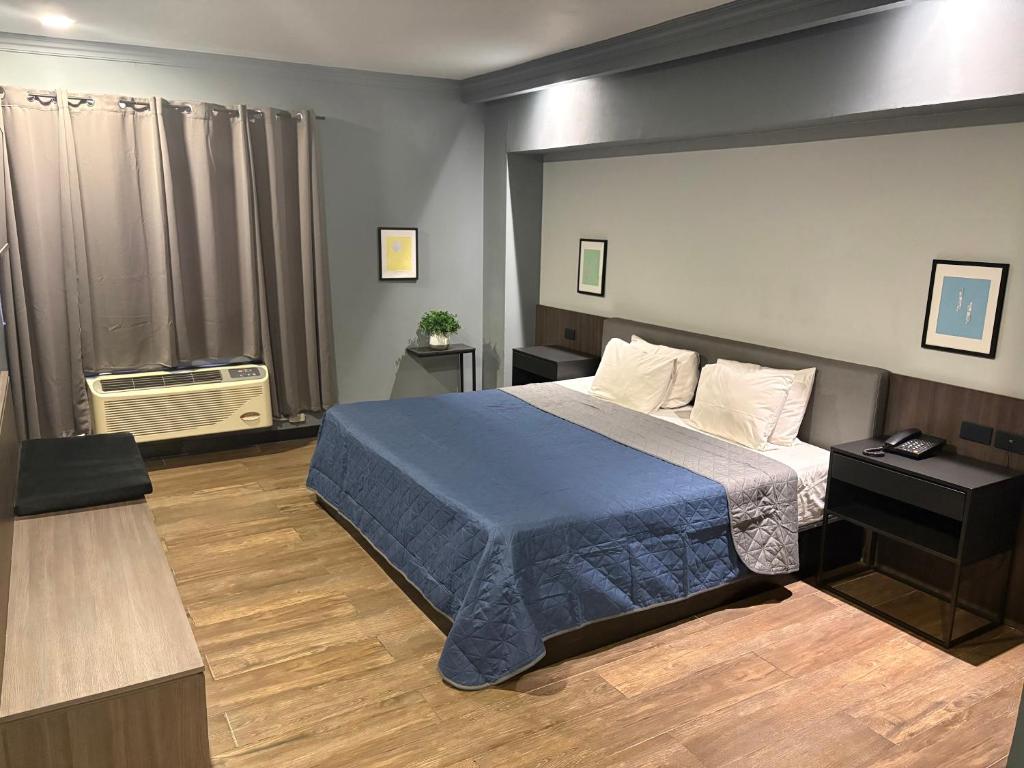 a bedroom with a bed with a blue blanket at Hotel Le-Gar in Monterrey