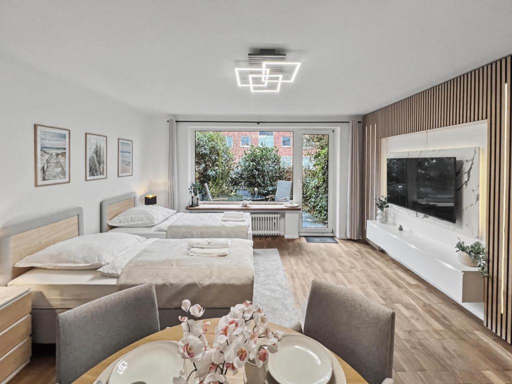 a bedroom with two beds and a table and chairs at charmantes Apartment bei Hamburg - Ruhe, Komfort & kostenloses Parken in Rellingen