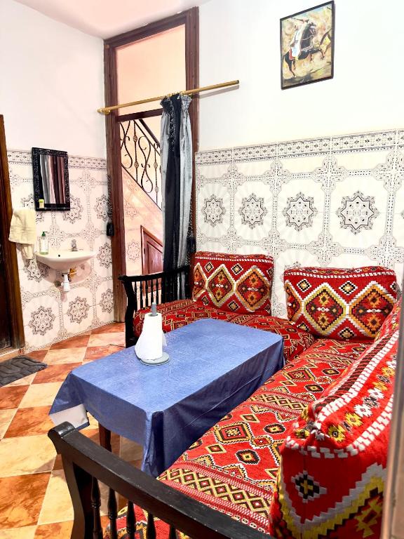 a living room with a couch and a table at Appartement confort et sérénité in Ikhorbane