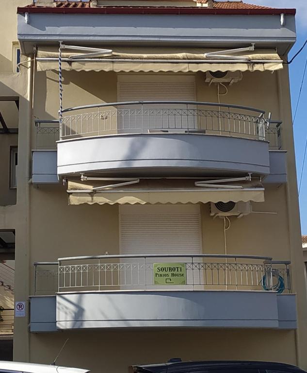 an apartment building with balconies and a sign on it at SOUROTI Pinios House in Sourotí