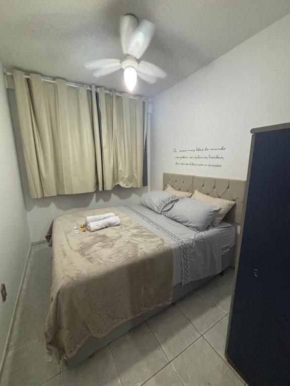 a bedroom with a bed with a ceiling fan at Apes Raizes Douradas in Campinas