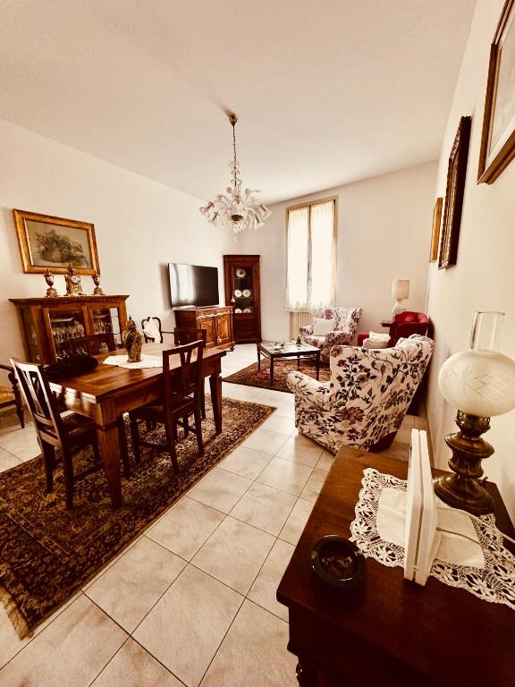 a living room with a table and a dining room at Novecento Apartment in Forlì