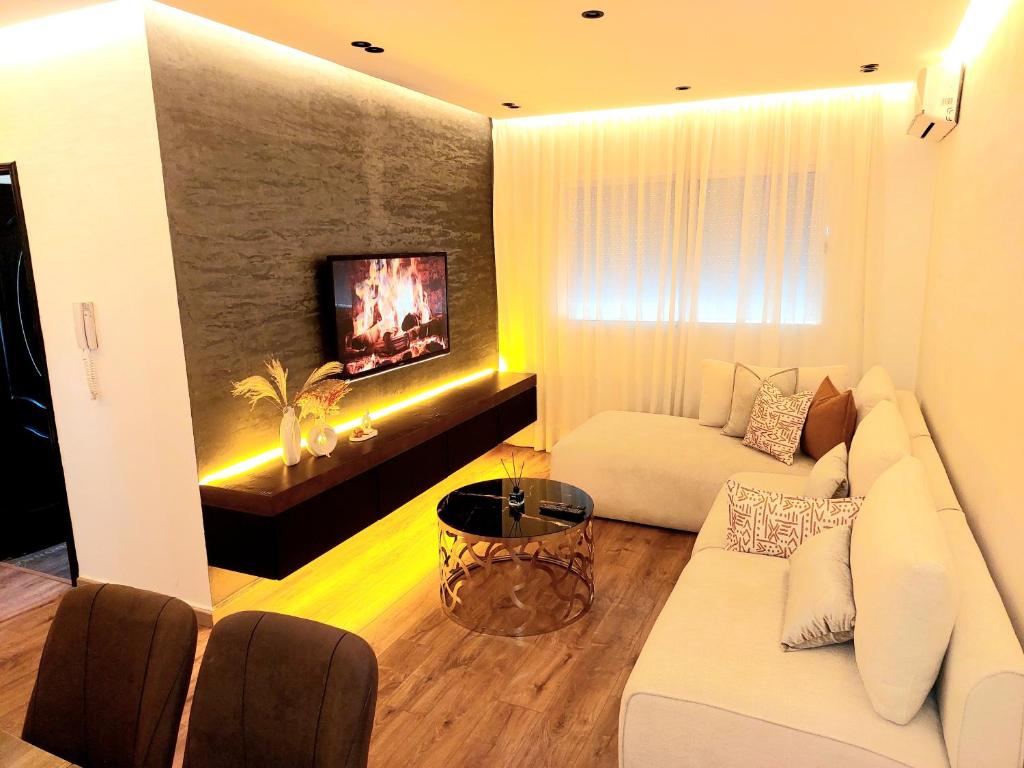 a living room with a white couch and a tv at Suite Bahiya unica in Fez