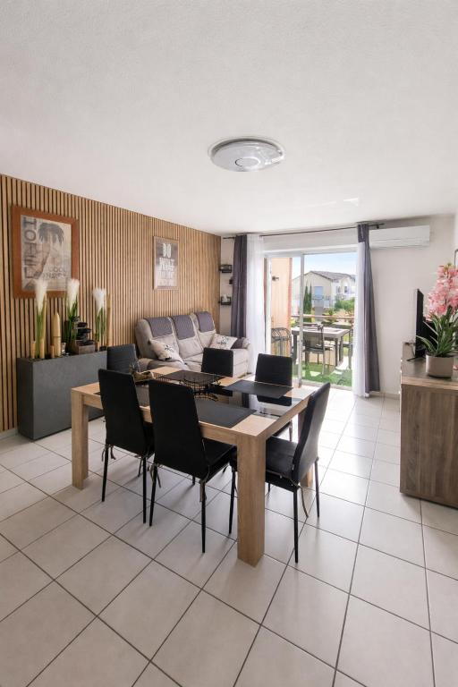 a living room with a table and chairs at Le Colibri in Fenouillet