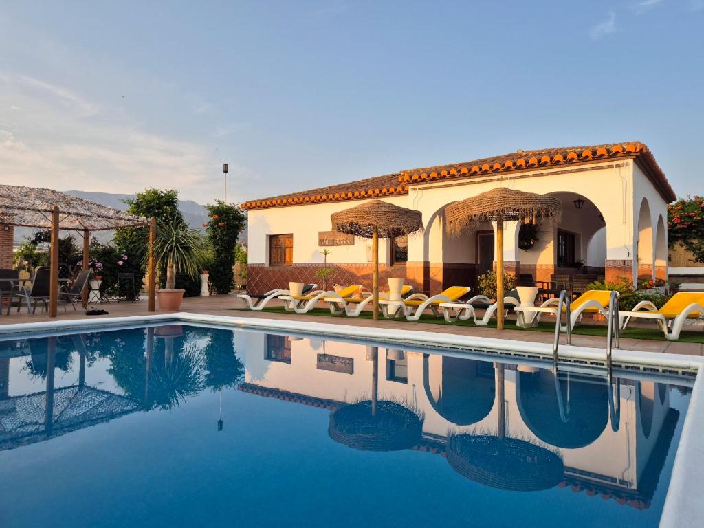 a villa with a swimming pool in front of a house at Villa Florida in Motril