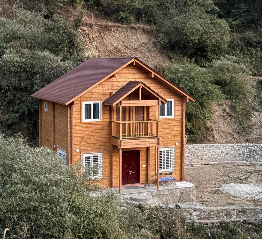 a house on the side of a hill at Samlaun Chalet and Retreat in Kanatal